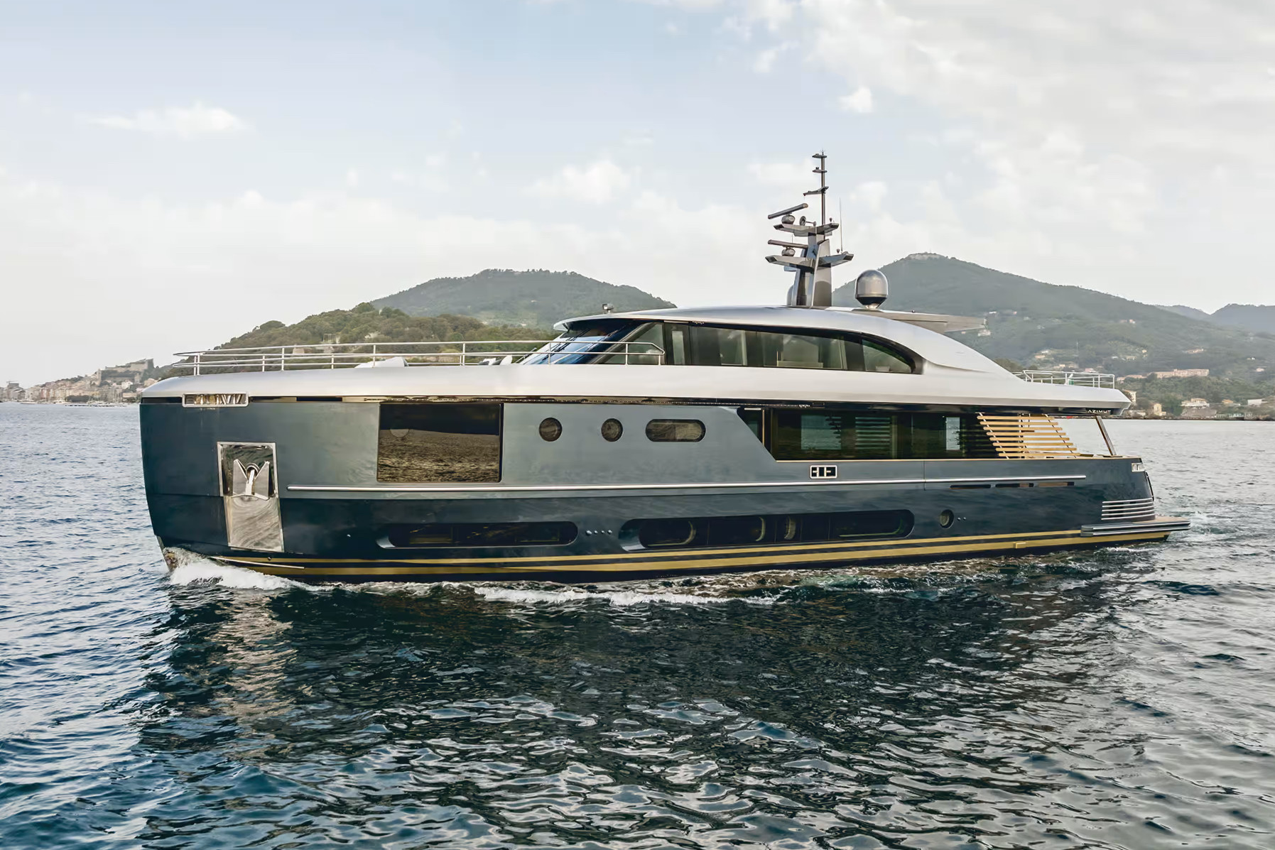 A motor yacht at anchor beside a green island