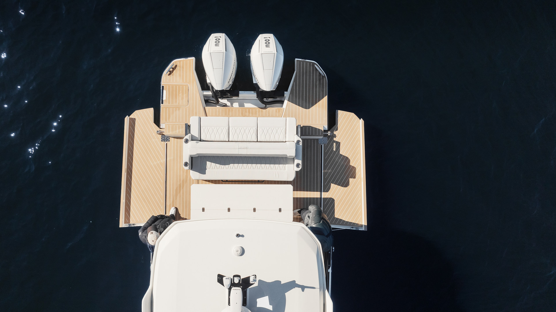 Overhead view of a yacht transom with twin outboards and a teak bathing platform