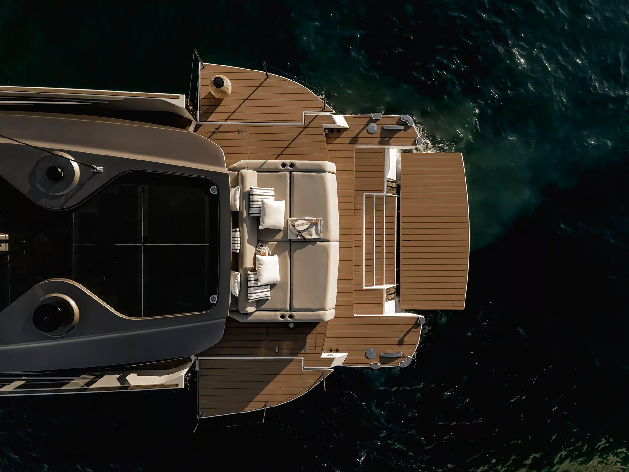 Overhead view of a motor yacht's aft deck opened out to the sea